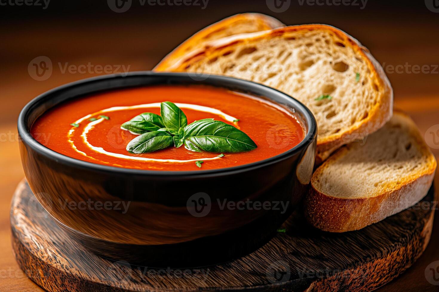 bowl of tomato soup garnished with fresh basil, served with slices of toasted bread. rich color and creamy texture create comforting and inviting meal experience photo