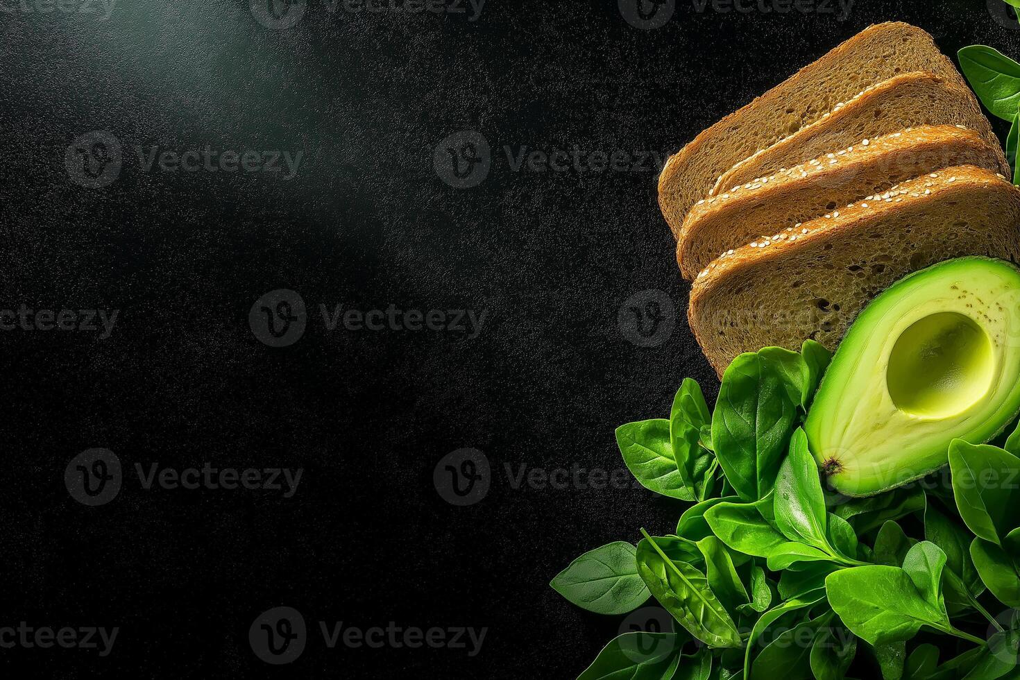Fresh avocado and whole grain bread on dark background with greens photo
