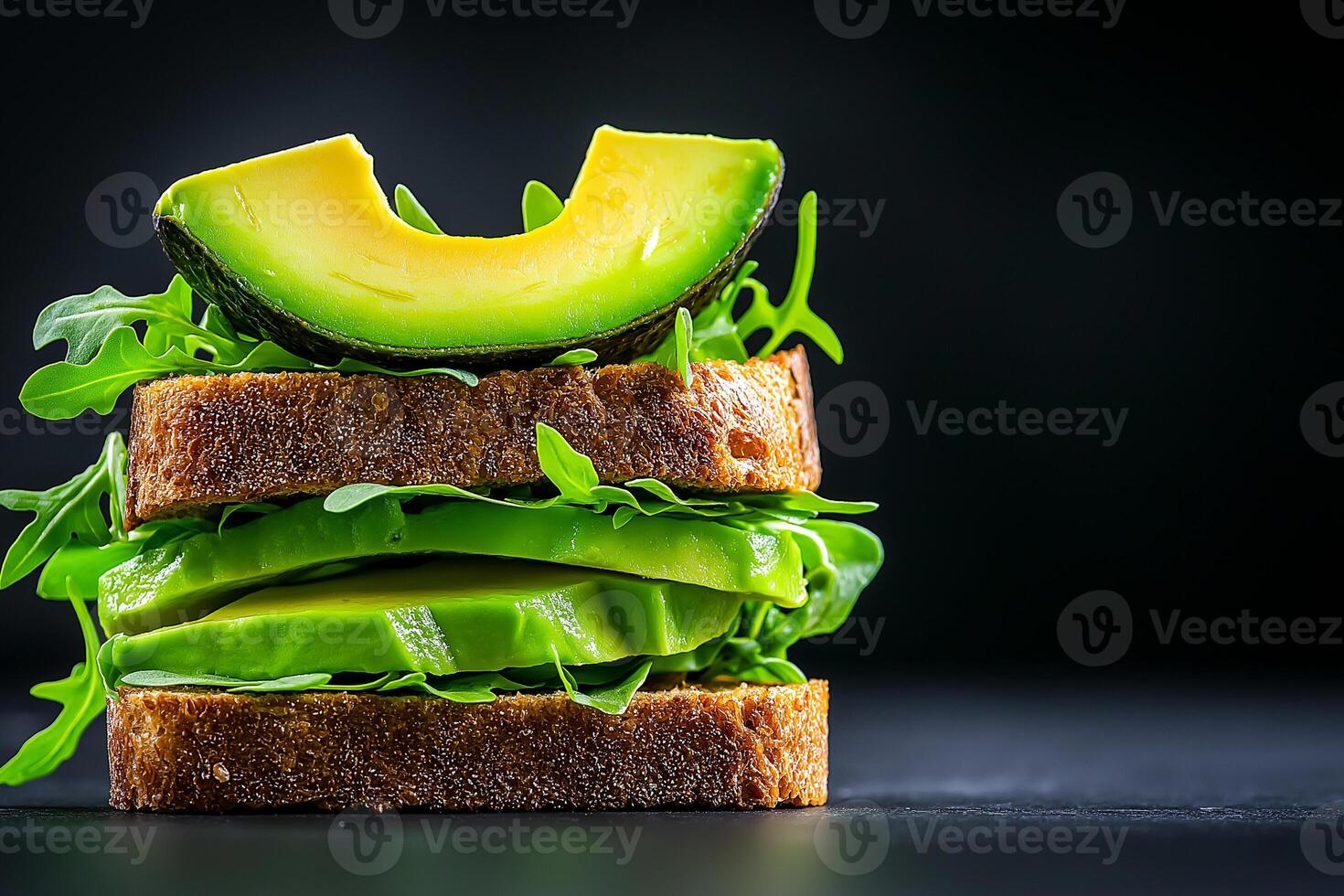 delicious stack of whole grain bread layered with fresh avocado slices and leafy greens, showcasing vibrant green color palette. This healthy sandwich is perfect for nutritious meal photo