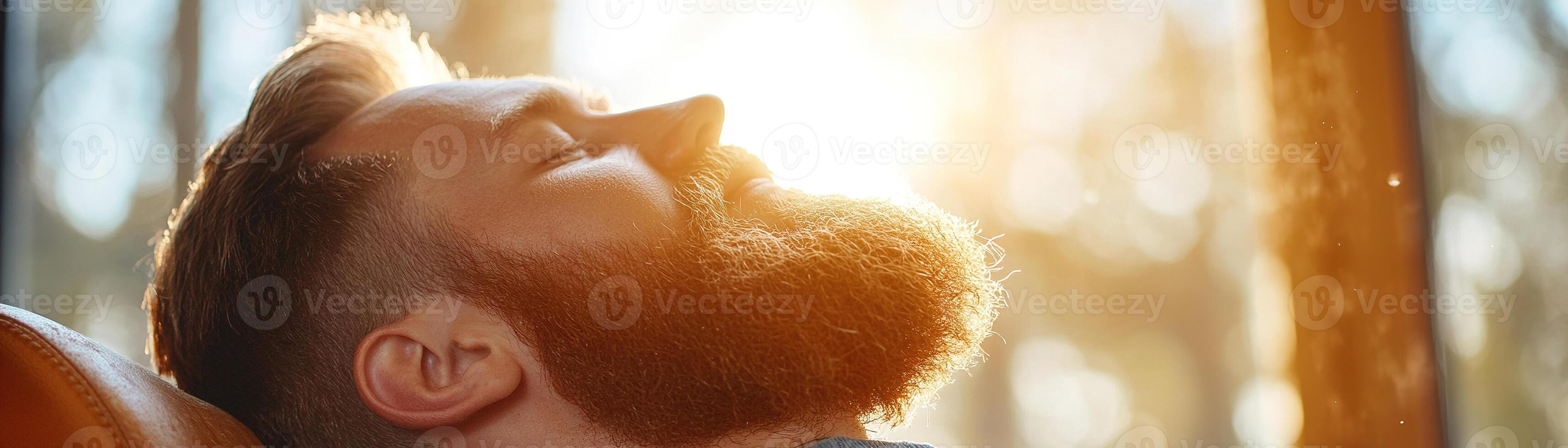 A skilled barber carefully trims a client's beard in a high-end barbershop, illuminated by soft golden sunlight pouring through large windows, creating a serene atmosphere photo