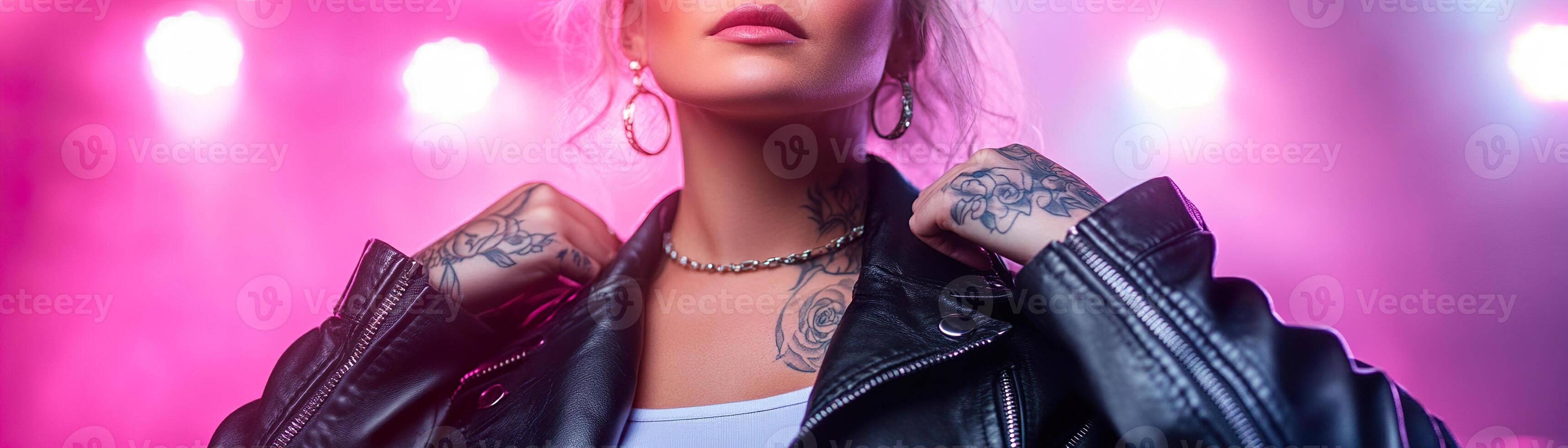 Standing confidently at a rock concert, a fierce plus-size woman with intricate tattoos showcases her style in a black leather jacket against a backdrop of soft-focus neon lights photo