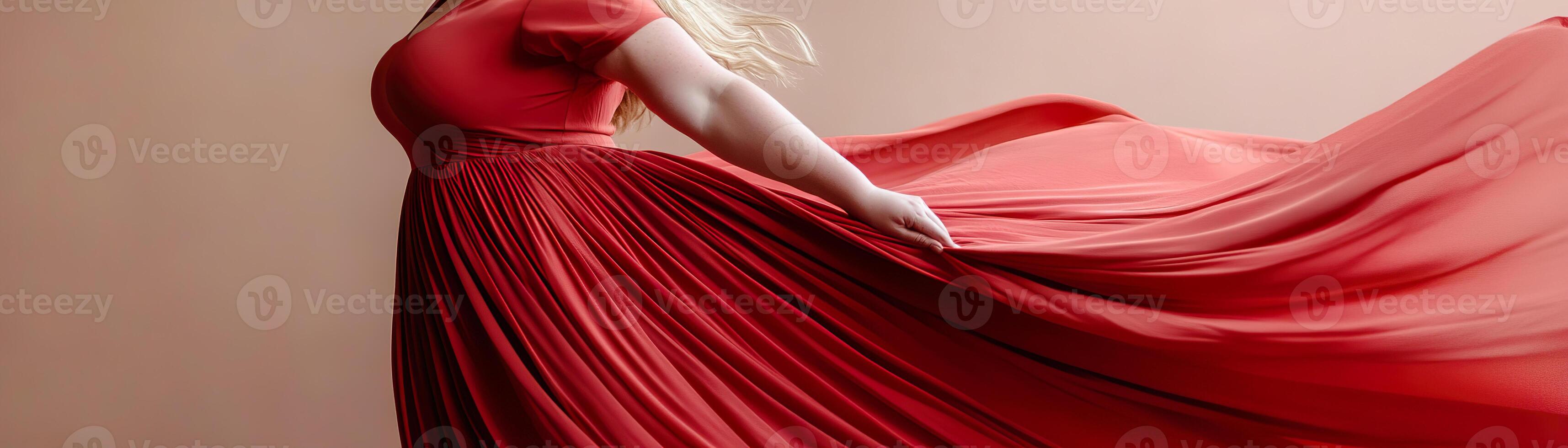 A plus-sized woman revels in a flowing red dress, her fabric billowing as if suspended in mid-air. The warm lighting enhances the dramatic and elegant storytelling of the moment photo