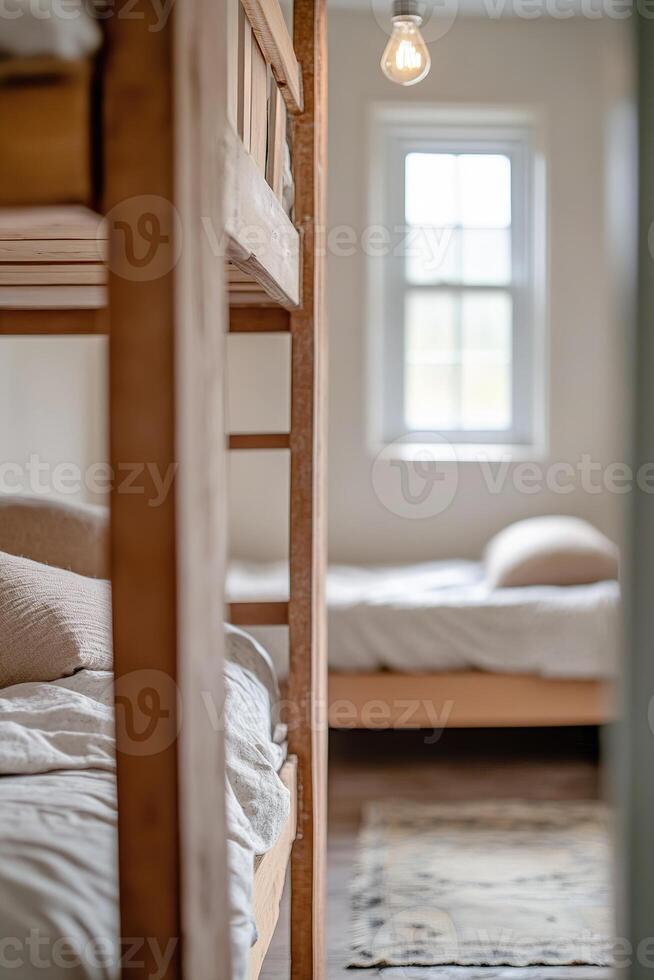 This small shared hostel room showcases two wooden bunk beds with mismatched bedding. A single lightbulb hangs above, illuminating the rustic space with travel vibes and a warm feel photo