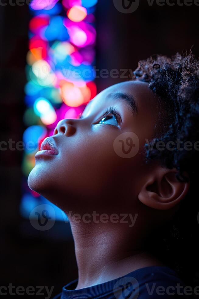 A young child stands inside a church, mesmerized by the vibrant stained glass light streaming down, casting colorful patterns on their face, creating a moment of spiritual awe photo