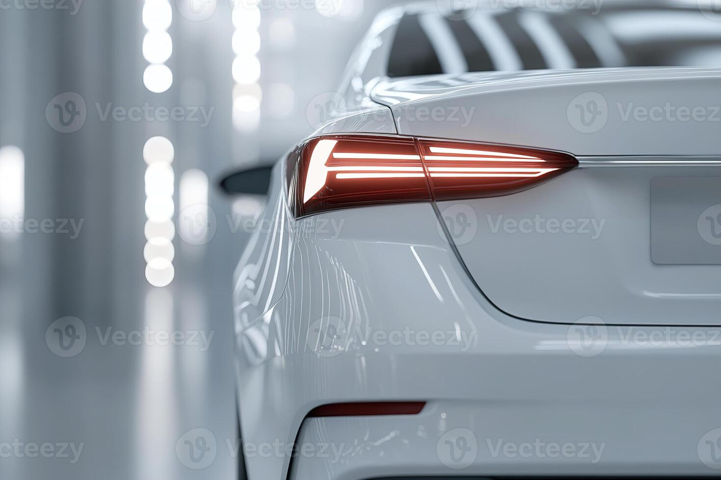 A modern white car is parked in a well-lit indoor area, highlighting its sleek tail light design. The soft ambient lighting creates a sophisticated atmosphere, emphasizing the vehicle's elegance photo