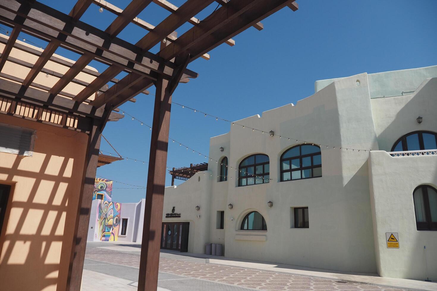 Qatar Doha 2 february 2025, Colorful architecture in desert town under clear blue sky at mina district photo