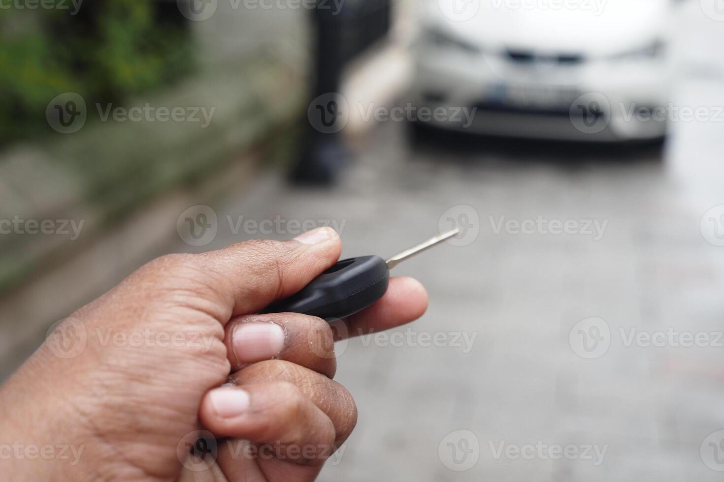 Unlocking a car using a remote key in an urban area photo