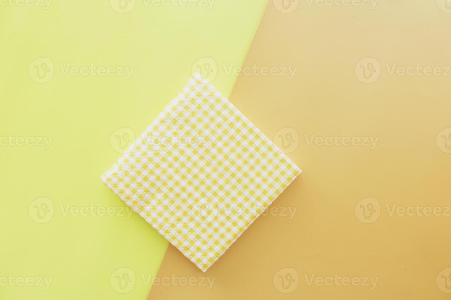 Decorative yellow checkered napkin on colorful background photo