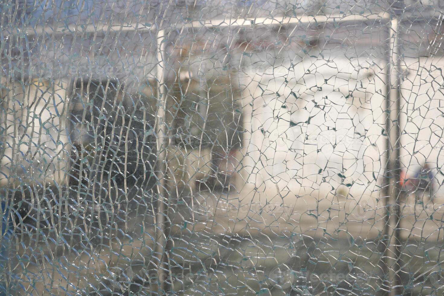 Broken glass window reveals blurred outdoor view in urban environment photo