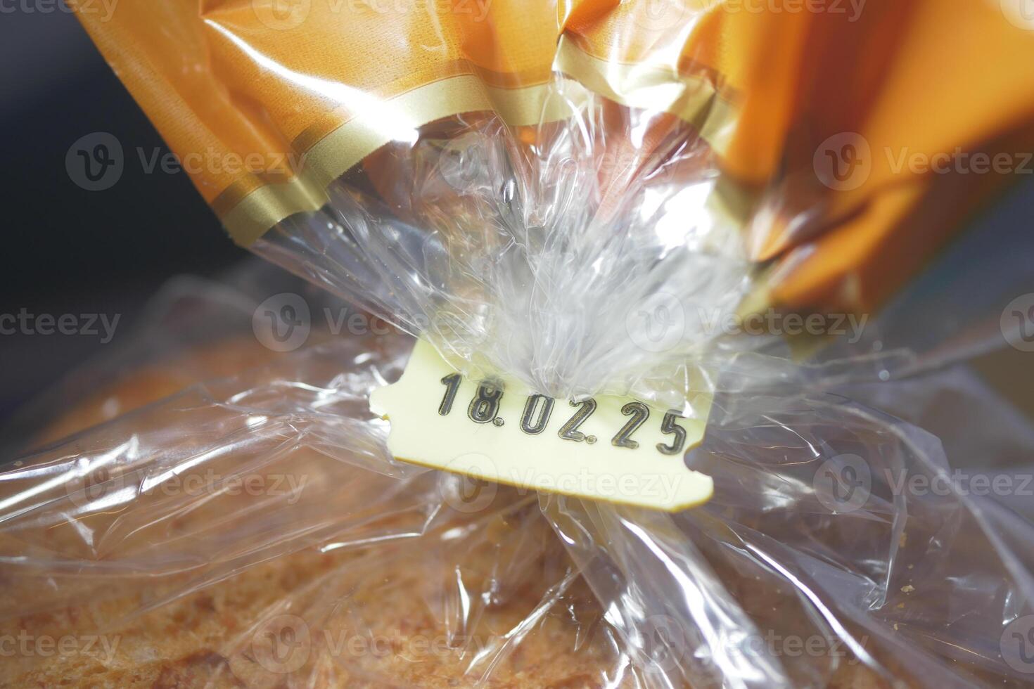 Date marked on a packaged loaf of bread in plastic wrap photo