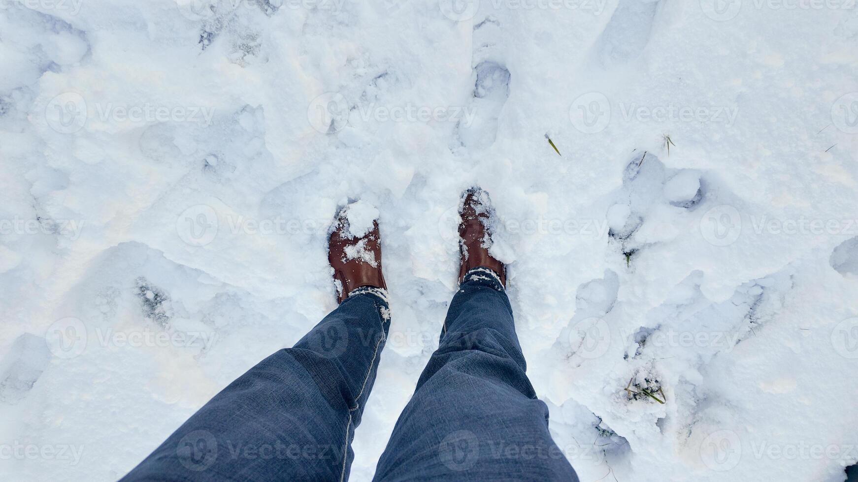 Boots covered in snow amidst a winter landscape in snowy conditions photo
