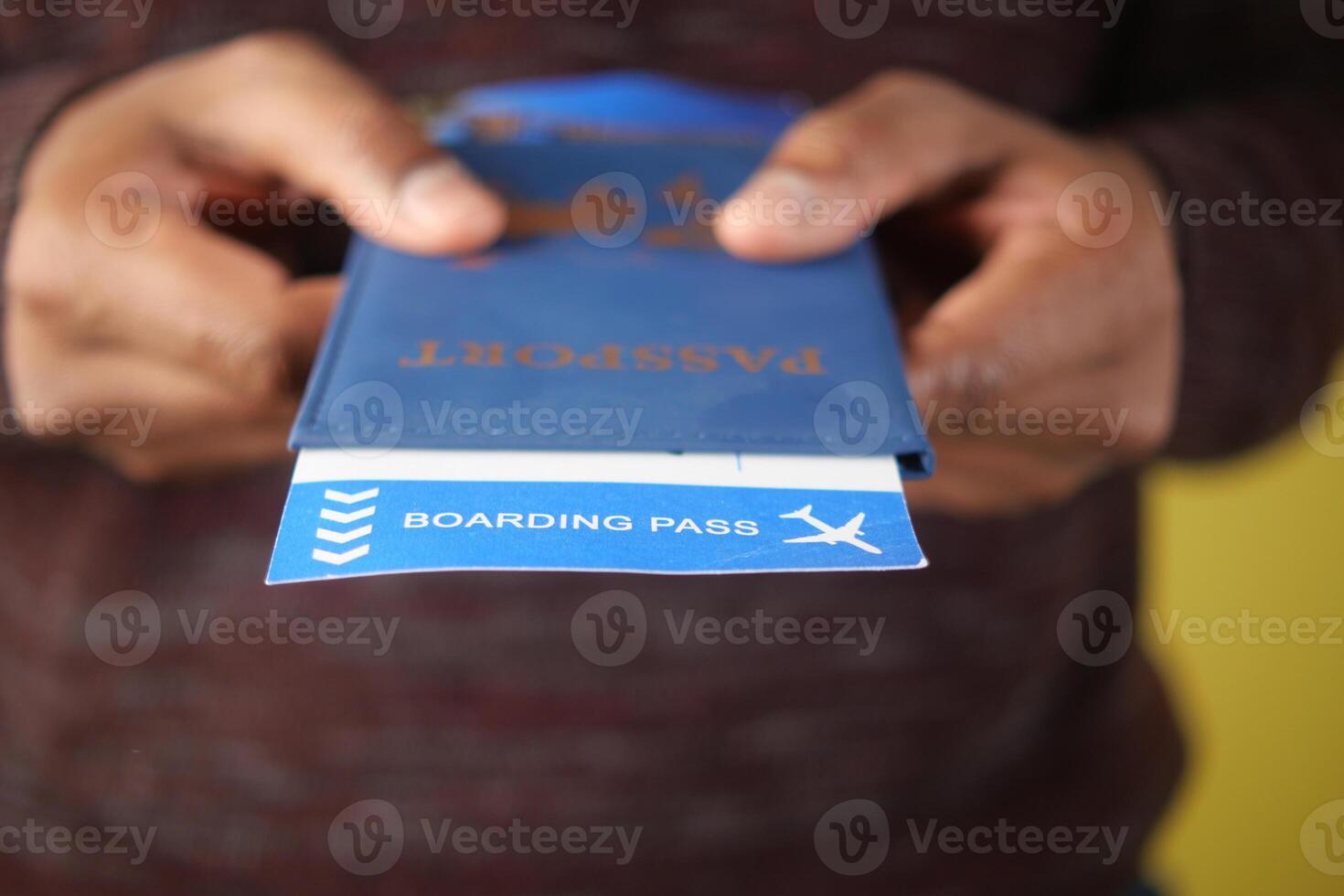 Individual holds a passport and boarding pass before traveling photo