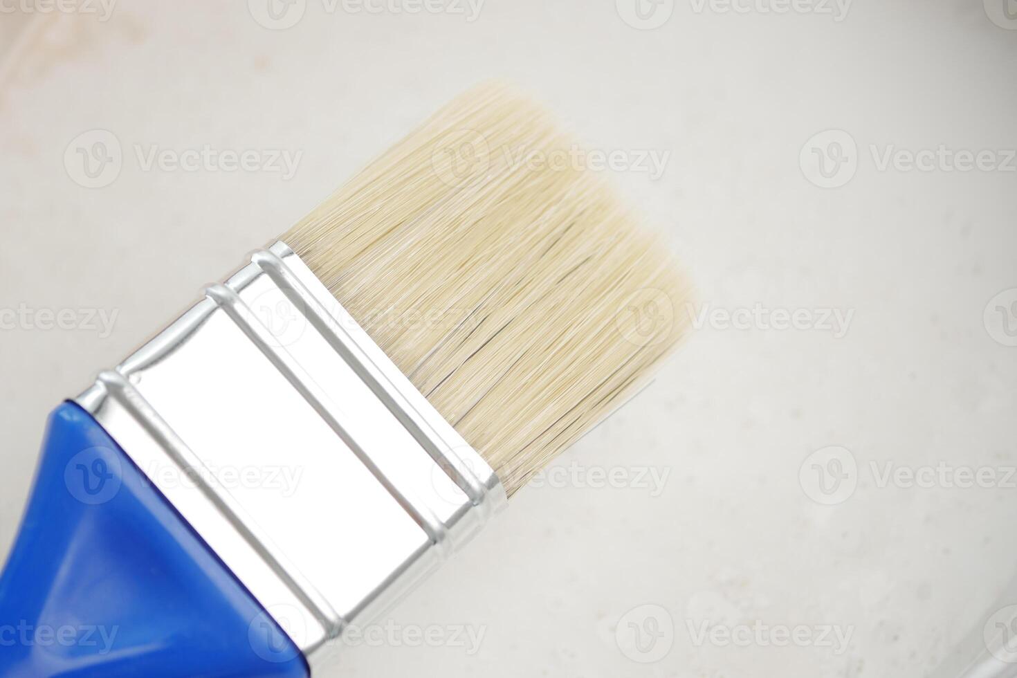 Close-up of a paintbrush resting on a light surface photo