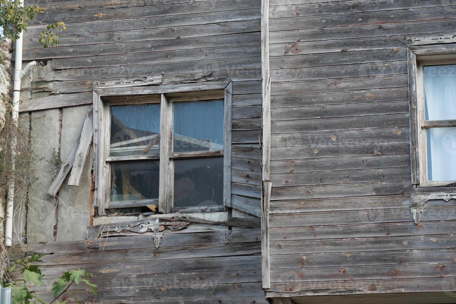 Old wooden building with broken windows and peeling paint photo