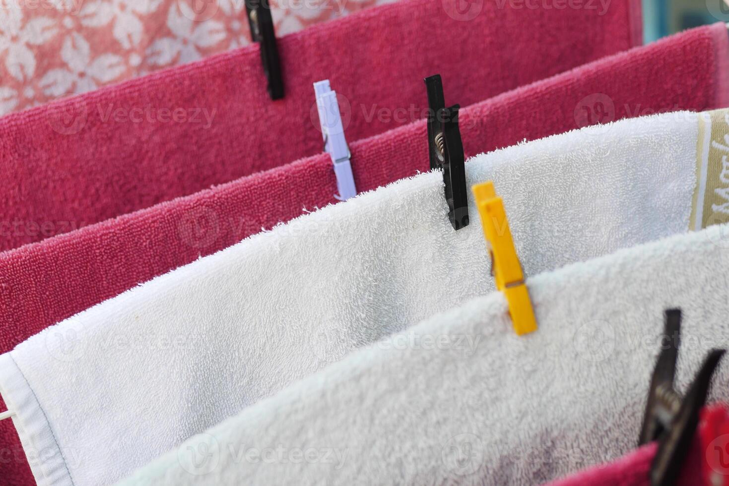 Towels drying on a clothesline under sunlight in a backyard photo