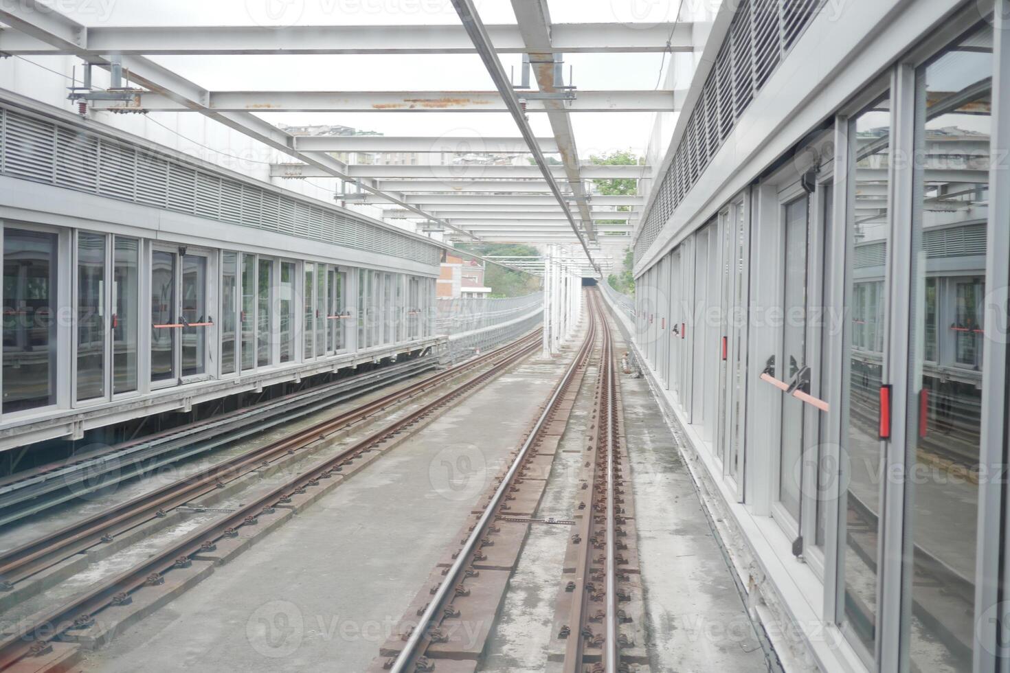 Elevated train tracks and station structure in urban environment photo