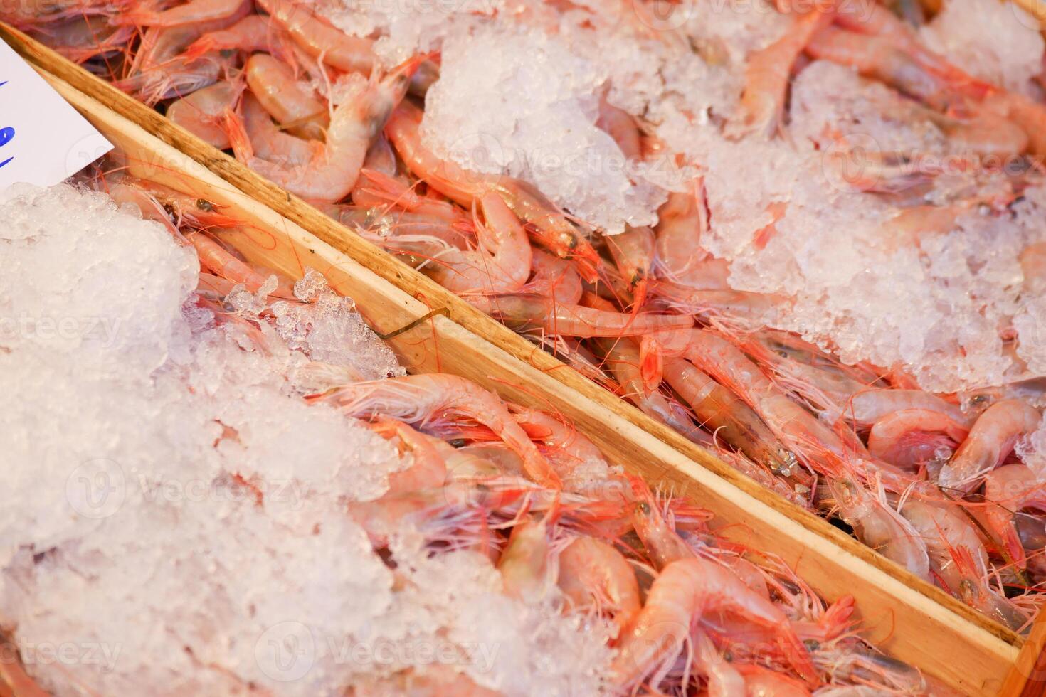 Fresh shrimp displayed on ice at a market stall in the afternoon photo