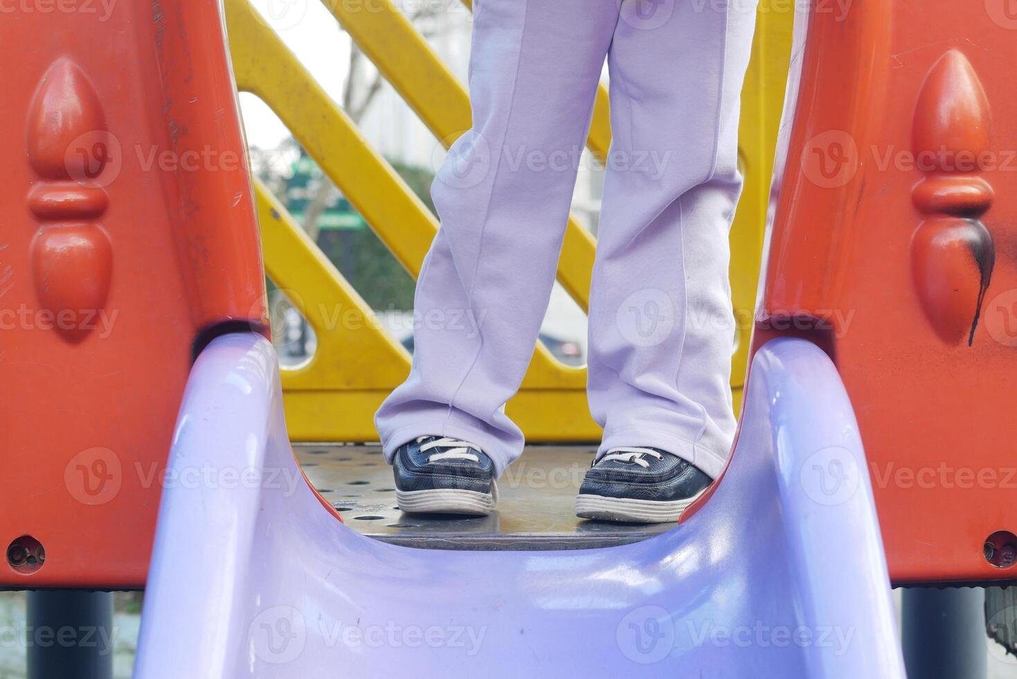 Child plays on colorful playground equipment during sunny day photo