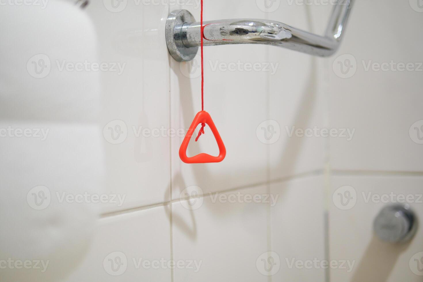 Red safety handle hanging in a bathroom near the shower photo
