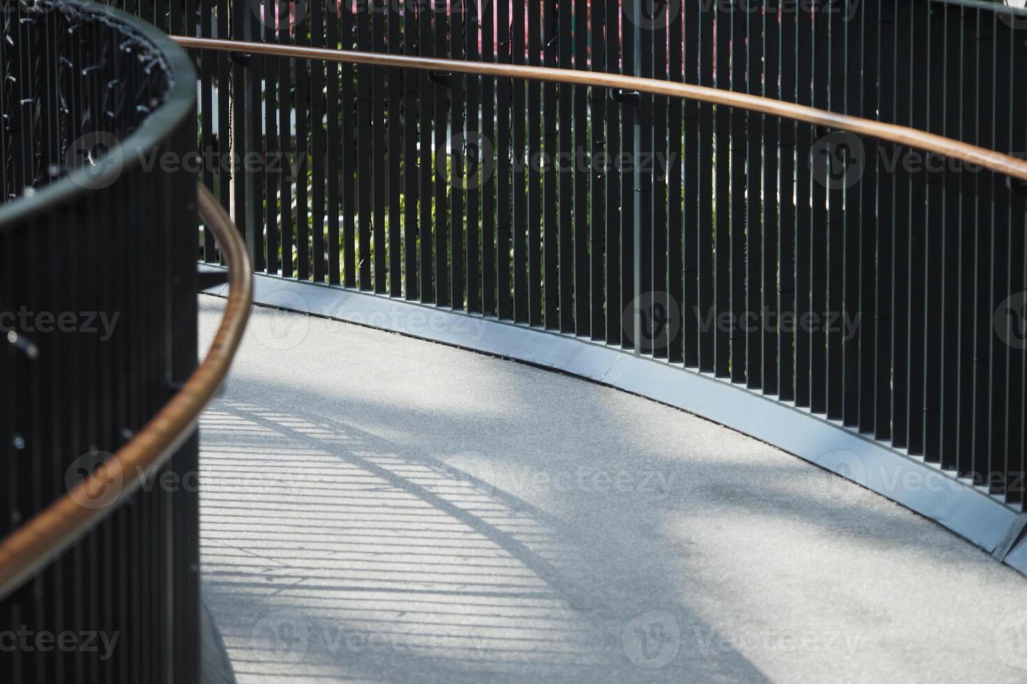 Curved walkway with shadows in urban park during bright daylight photo