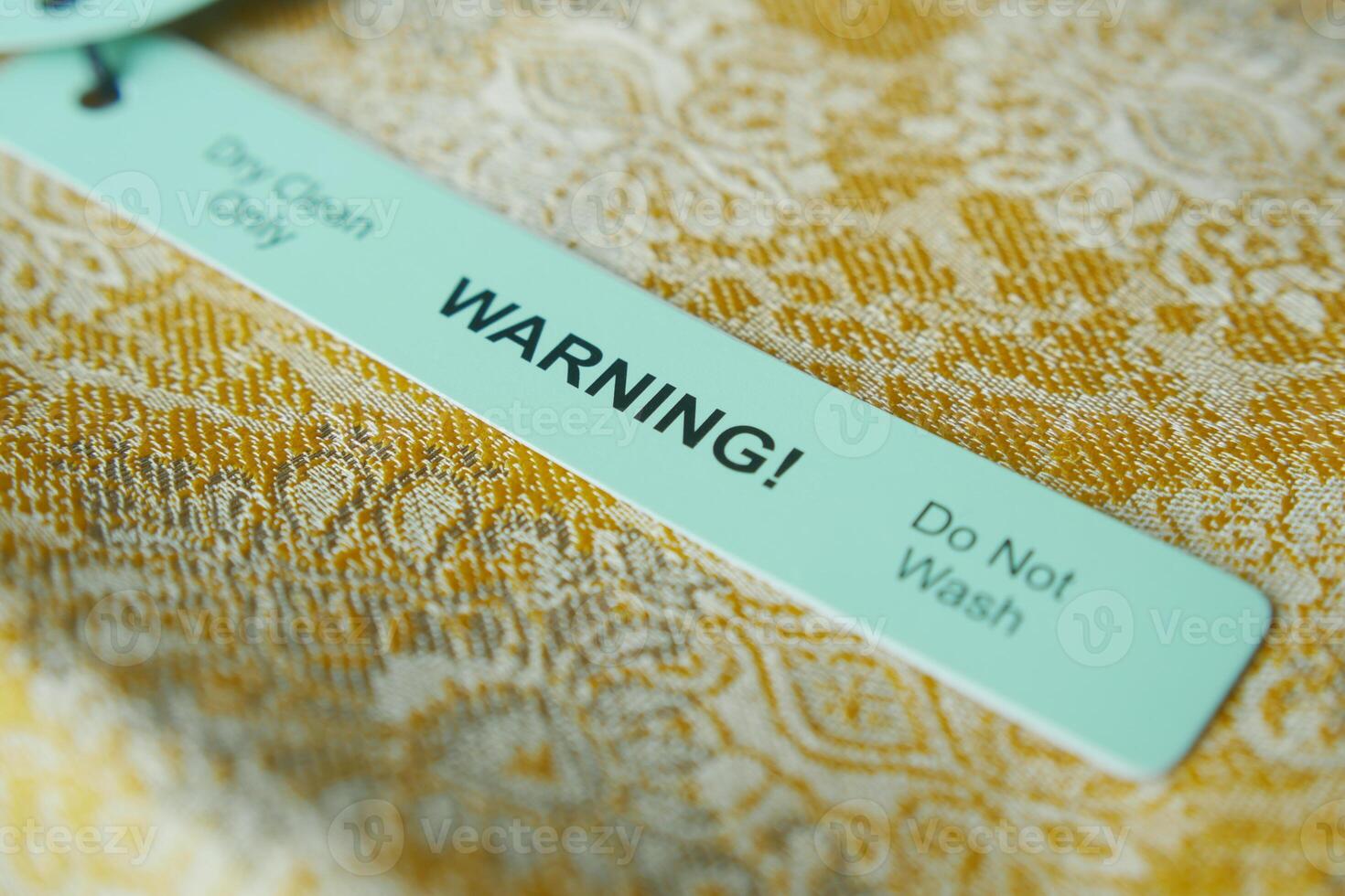Warning label for delicate fabric care on a textured background photo