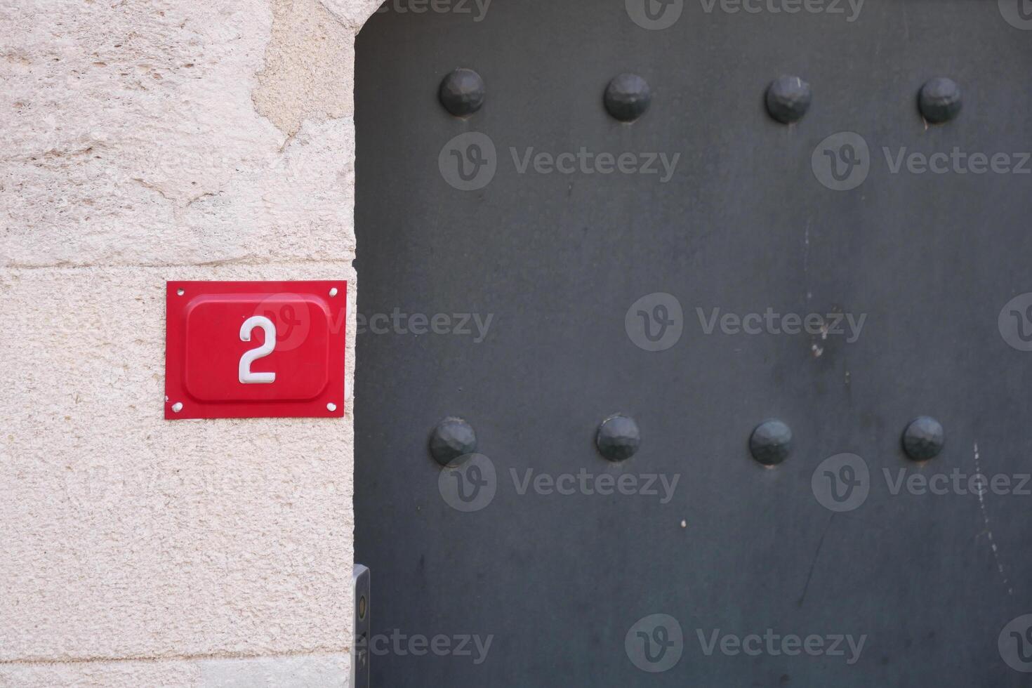 Red number two on entrance wall of a building photo