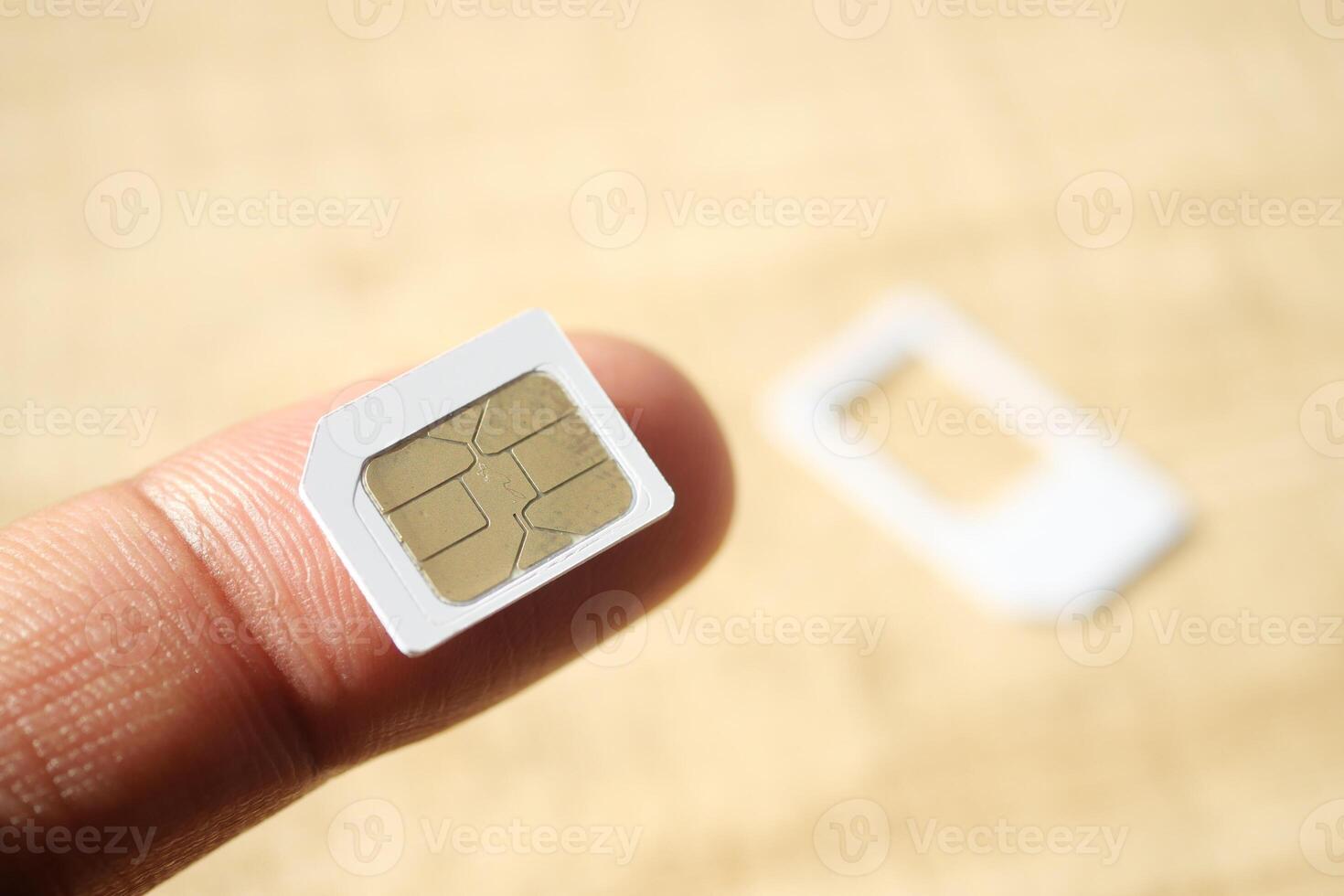 Holding a SIM card with a tray on a wooden surface photo