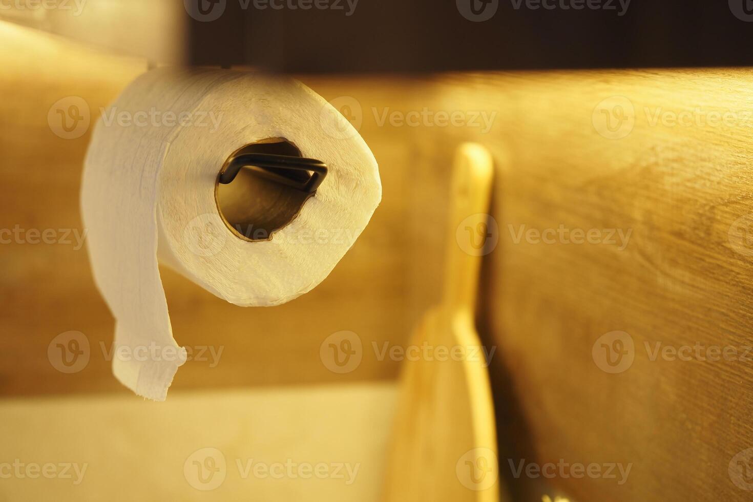 Paper towel roll hanging in a kitchen with wooden utensils nearby photo