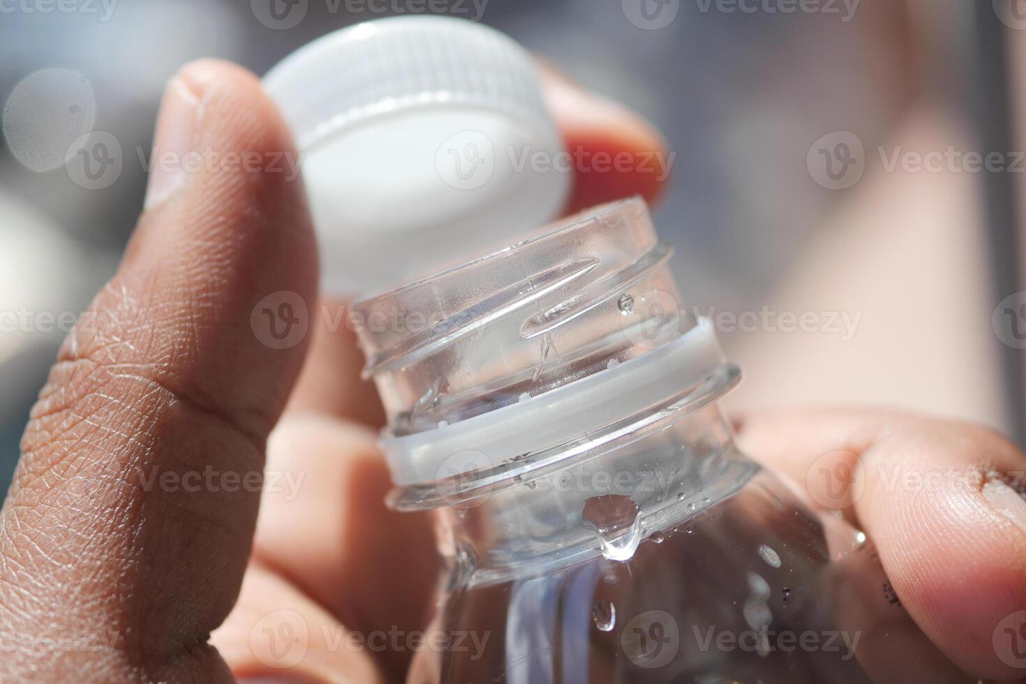 Closing a water bottle cap while outdoors on a sunny day photo