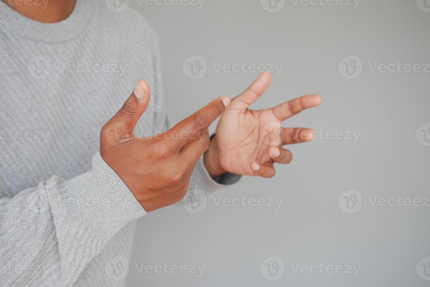 Hands gesturing in a creative expression against a simple backdrop photo
