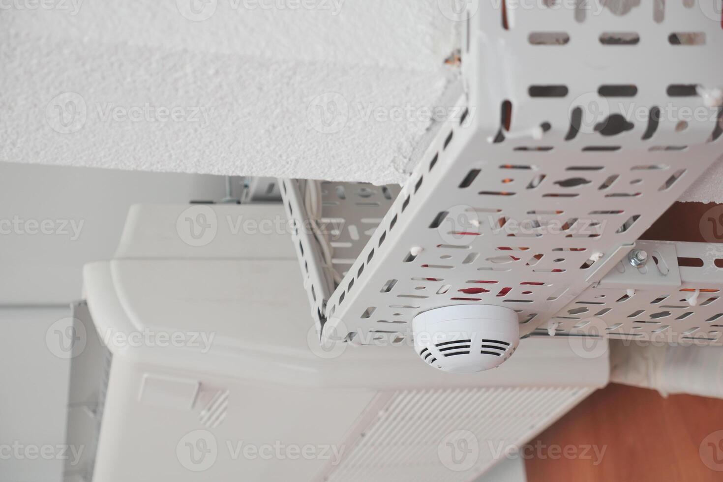 Ceiling smoke detector mounted in a modern indoor space photo