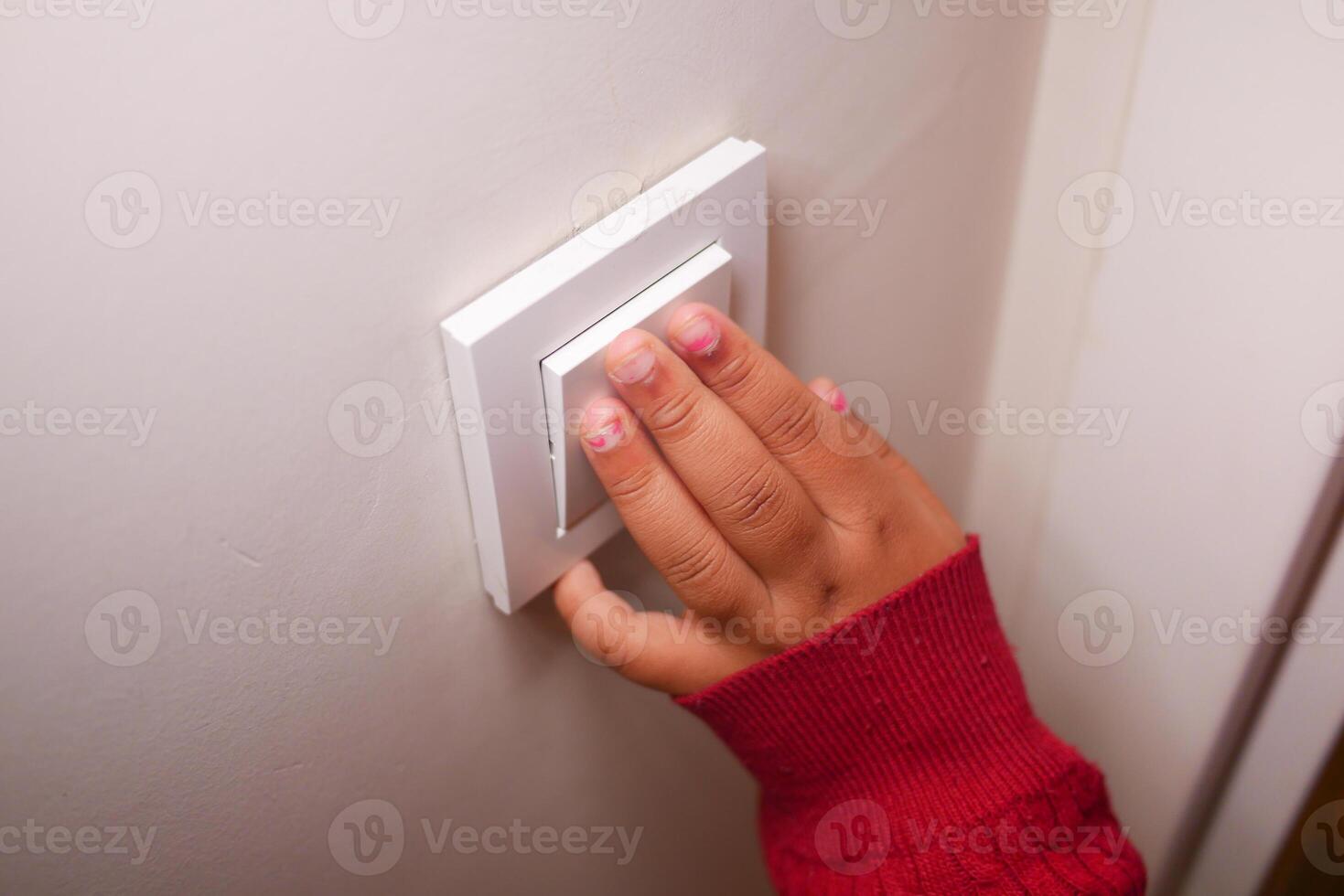 Child reaching to turn on light switch in cozy indoor setting photo
