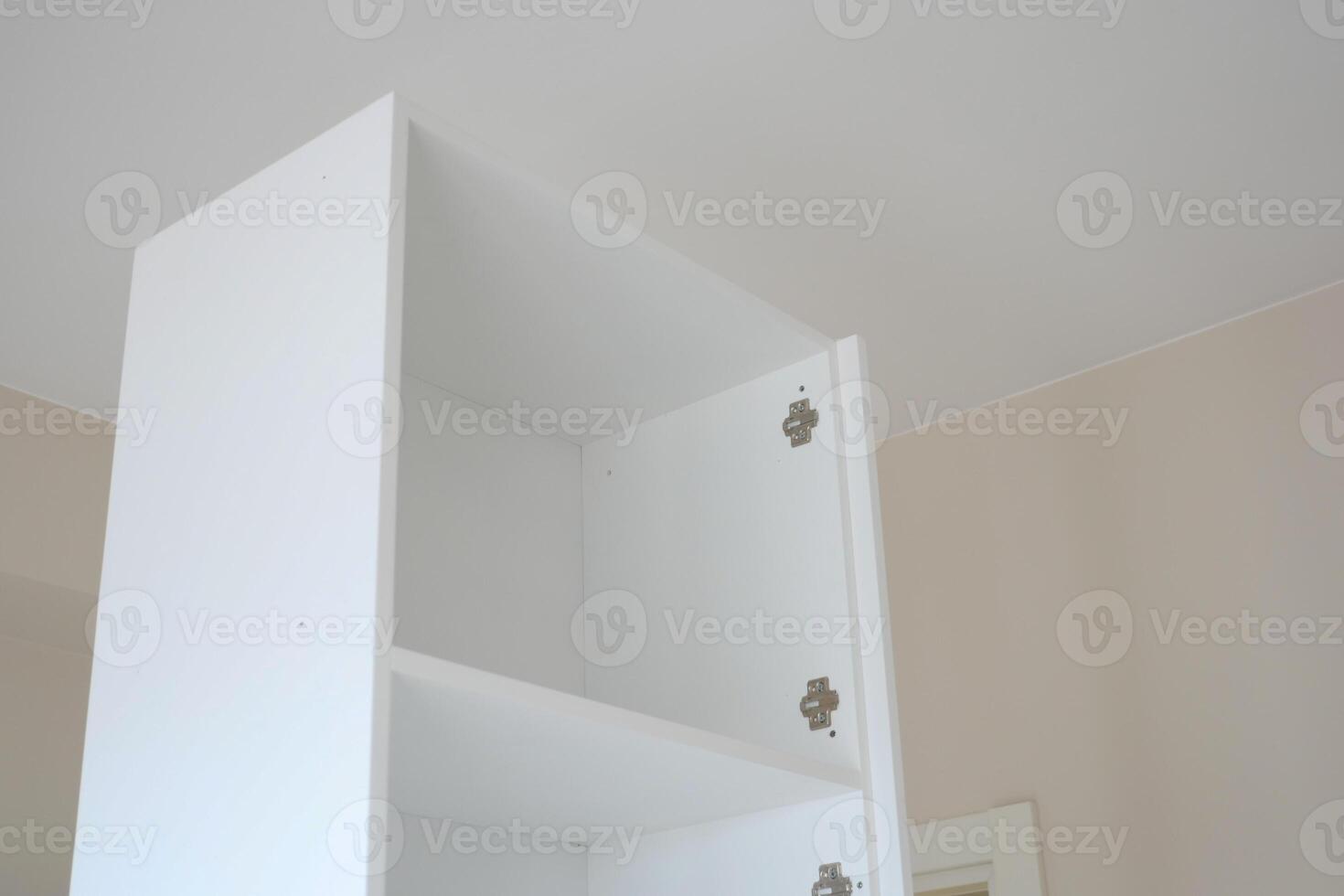 White cabinet with empty shelves in a bright room photo