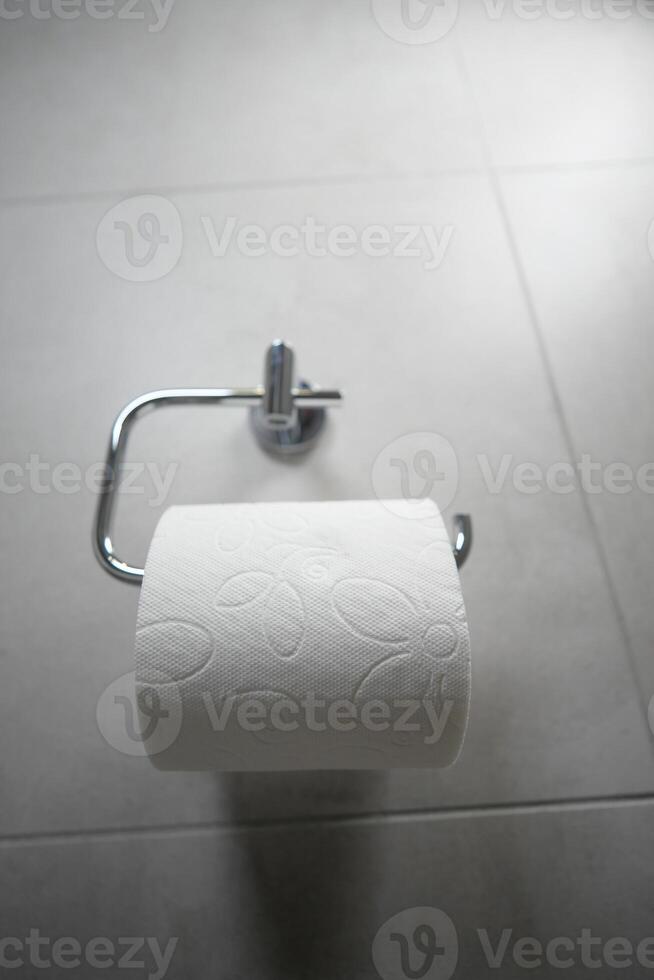 Toilet paper roll on holder in modern bathroom setting photo