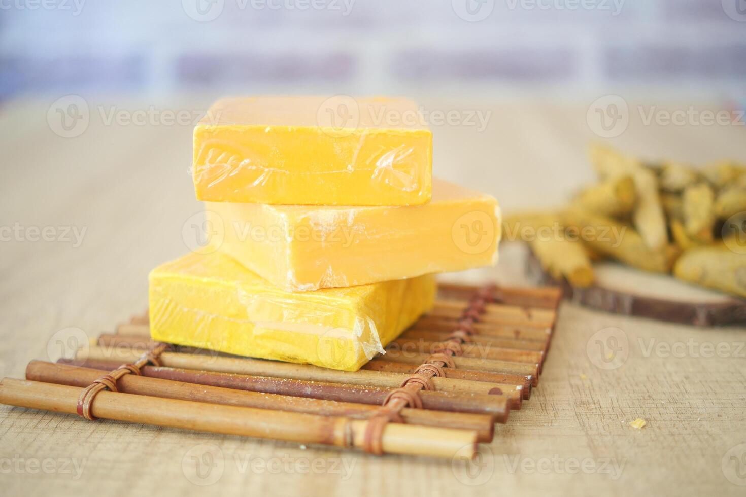 Yellow cheese blocks arranged on a bamboo tray with snacks photo