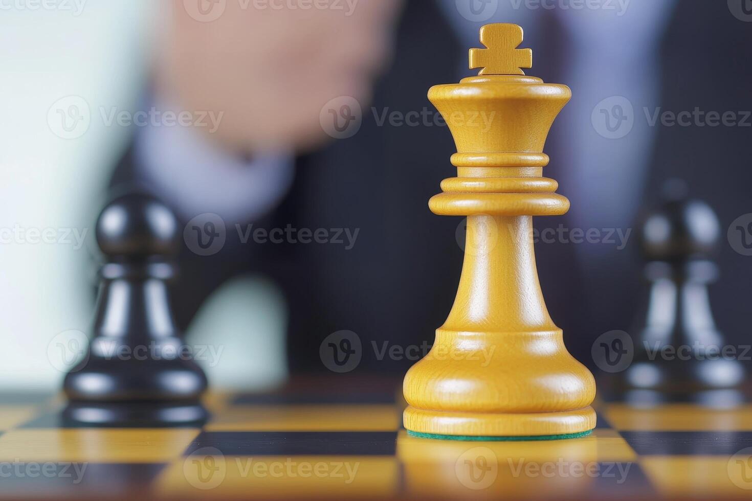 Entrepreneurship success mindset concept. A businessman focuses on a chess game with a prominent golden king piece in view. photo