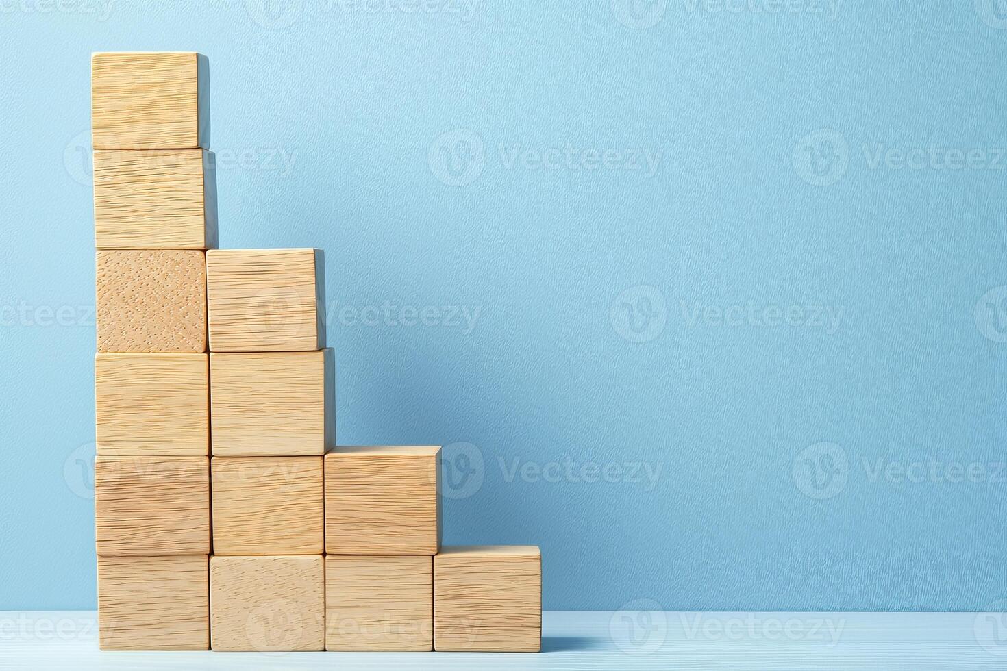 Growth mindset habits concept. Wooden blocks arranged in a growing staircase pattern against a blue background. photo