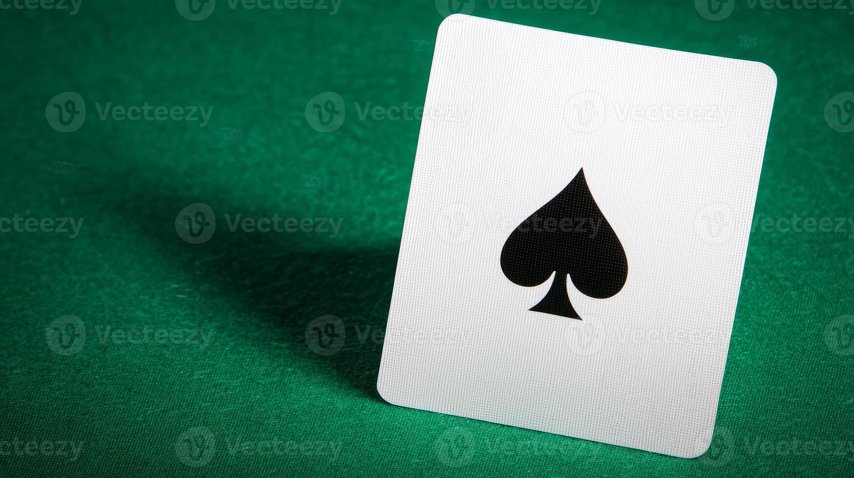 A close-up of a playing card featuring the spade symbol, set against a green background, evoking themes of gaming and chance. photo
