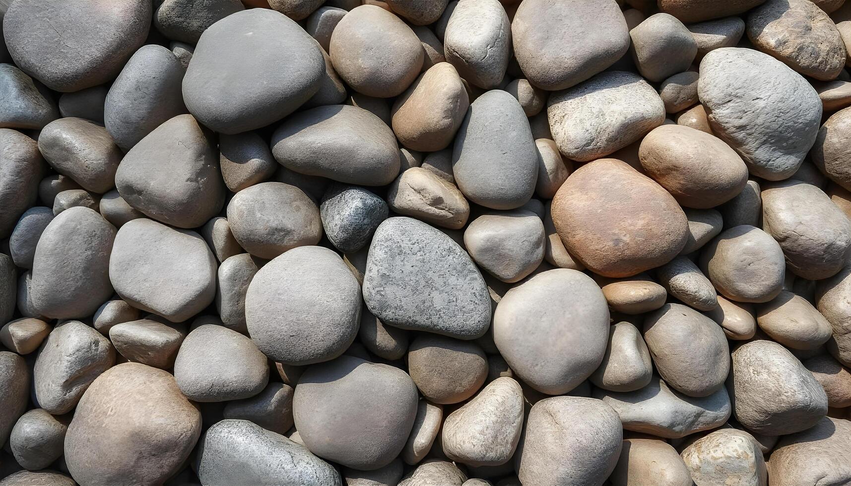 Wide angle smooth stone texture background showcasing a blend of smooth river stones, creating an organic and harmonious pattern photo