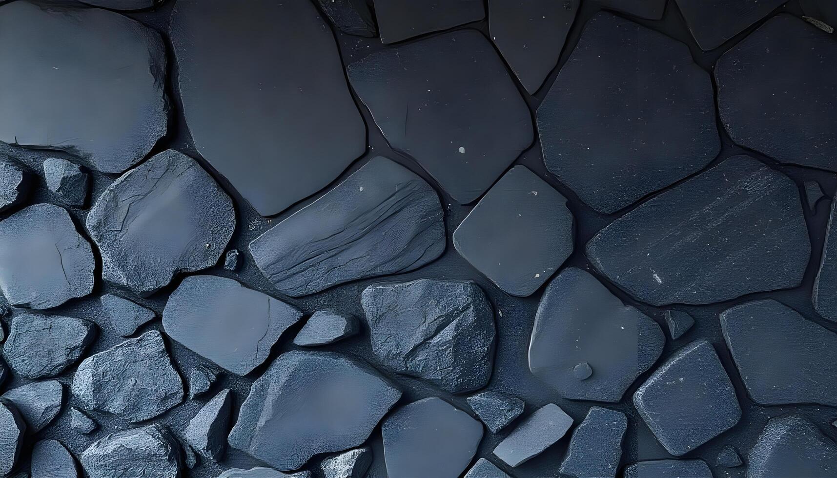Dark gray and black irregular stones arranged in a textured mosaic pattern photo