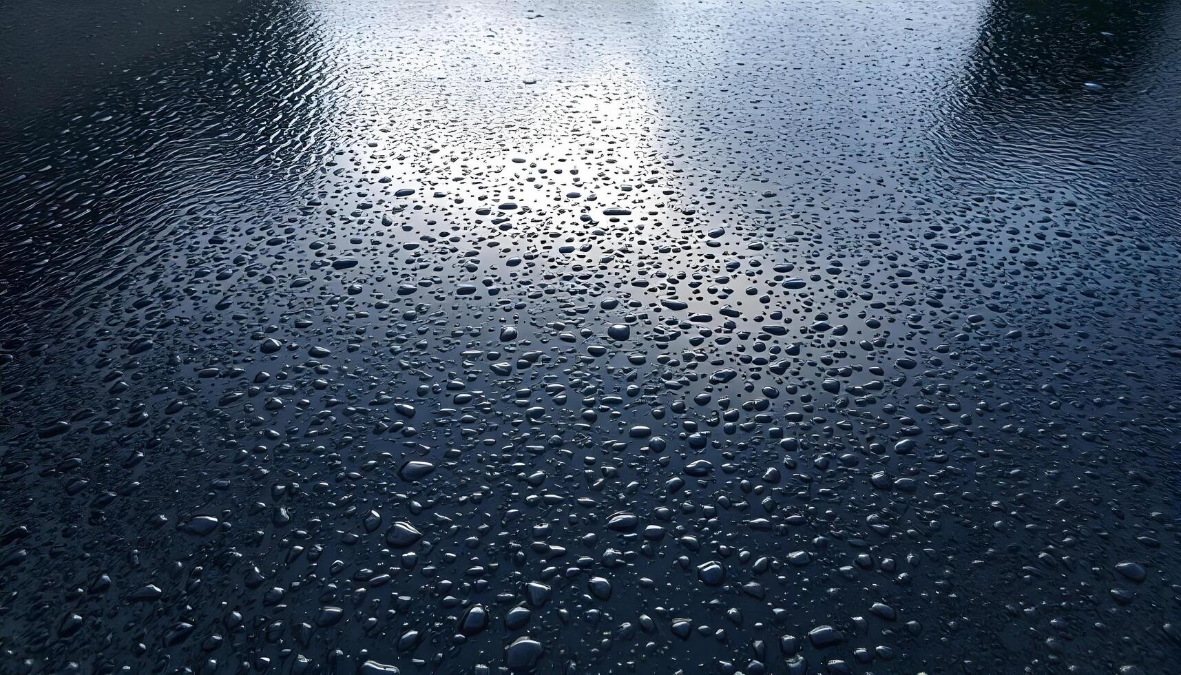 Tarmac texture background covered in a light layer of rain, reflecting a cloudy sky and showing water droplets on the surface photo