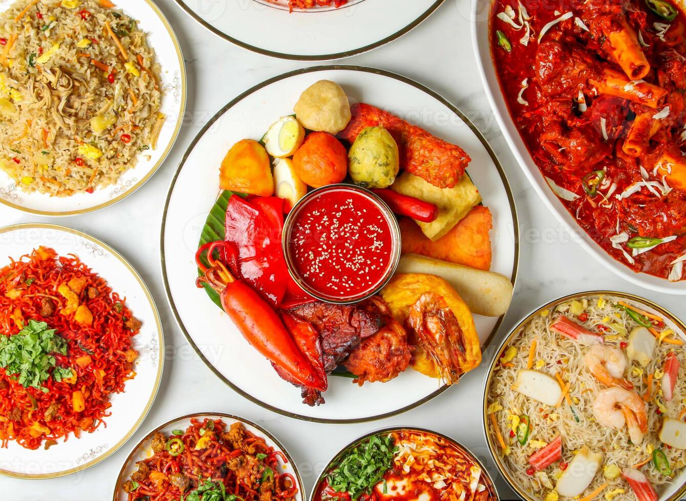 Nasi Goreng Putih Ikan Bilis, bee hoon goreng seafood, Mutton Rogan Josh, curry, and karahi served in plate isolated on marble background top view of singapore food photo