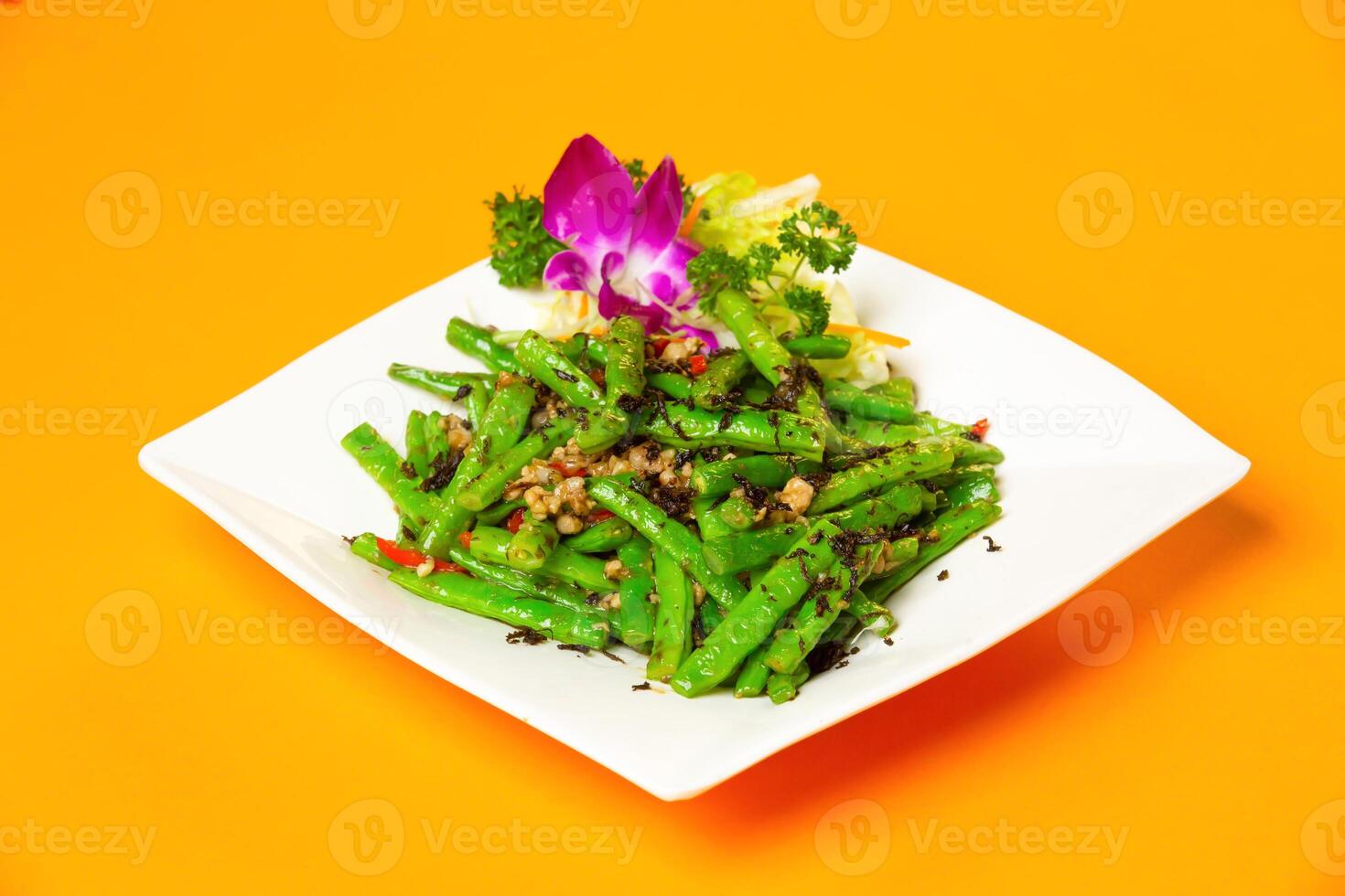 Stir Fried Green Beans with Minced Pork and Olives served in plate isolated on orange background side view of hong kong food photo