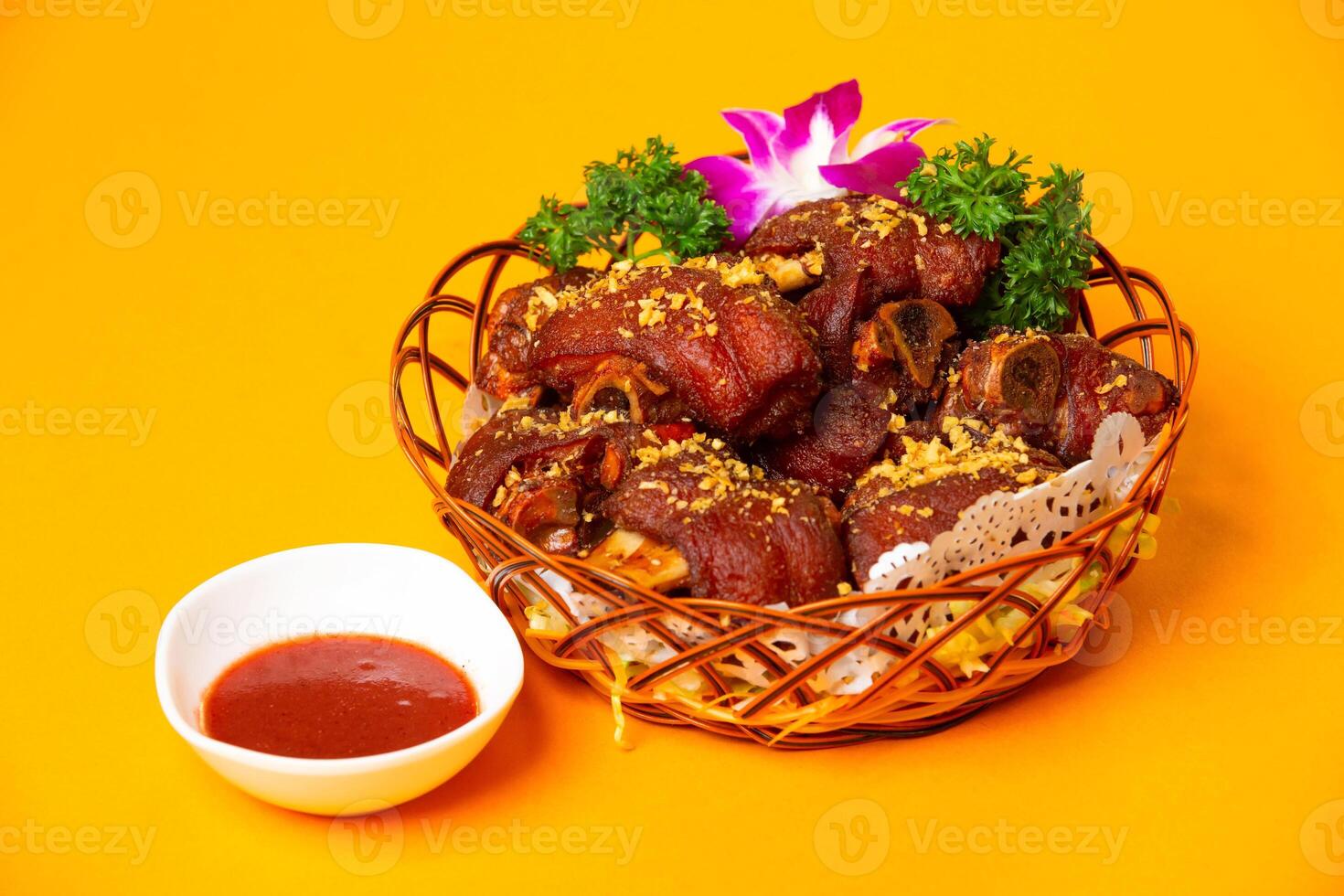 Crispy Fried Pig Trotters or pork Knuckle with Red Bean Curd served in plate isolated on orange background side view of hong kong food photo