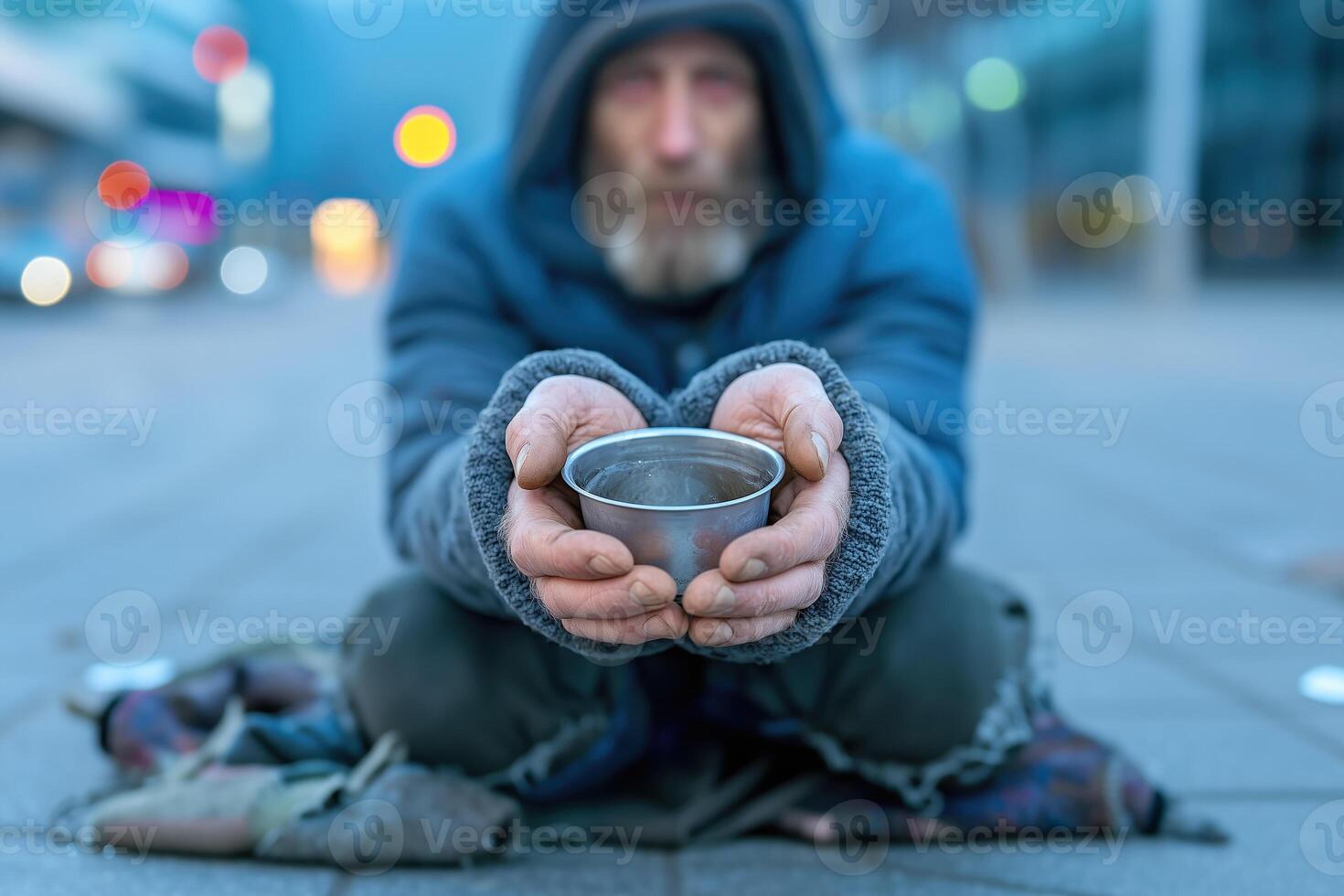 Homeless person sitting in the street and begging for money. photo