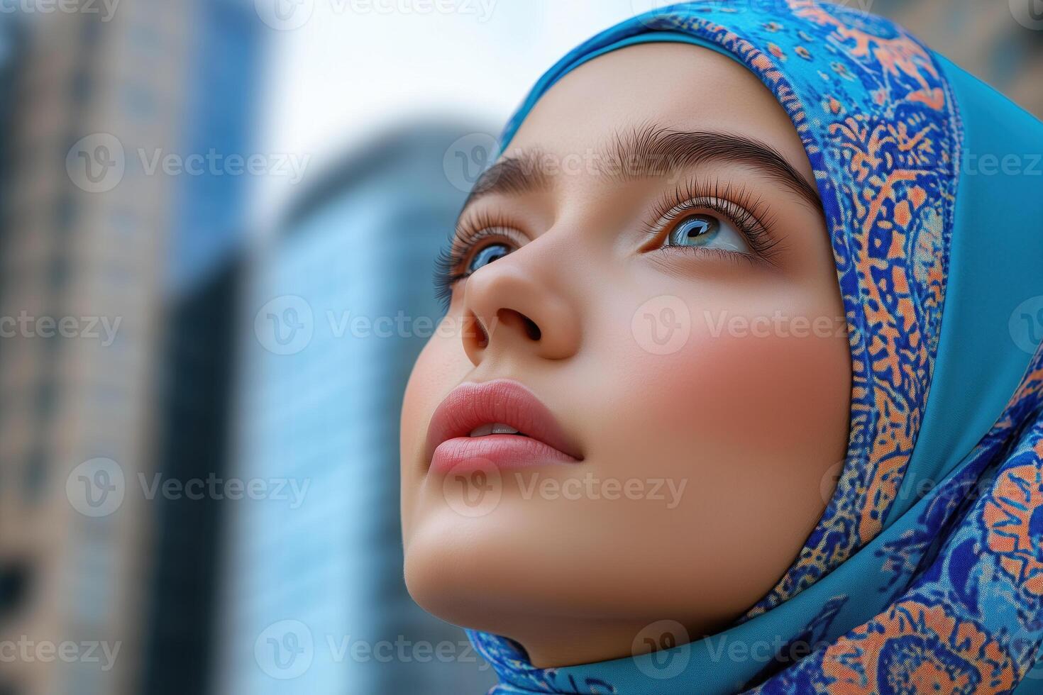 Portrait of beautiful young muslim woman with blue headscarf on a city background photo