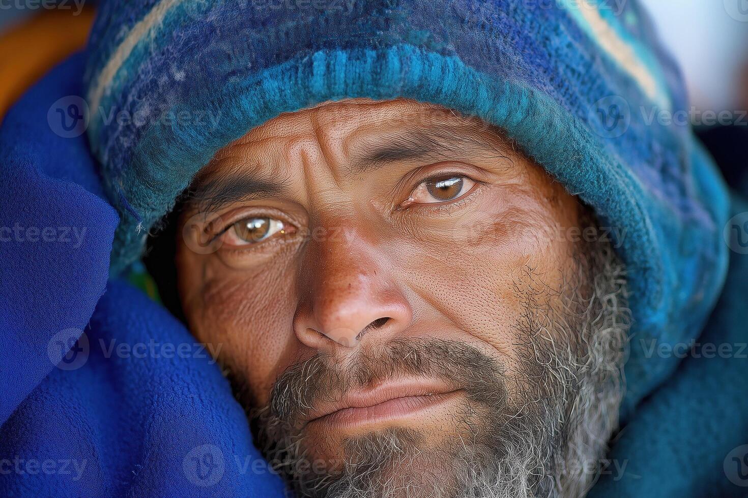 Portrait of an adult houseless man in a blue hat. photo