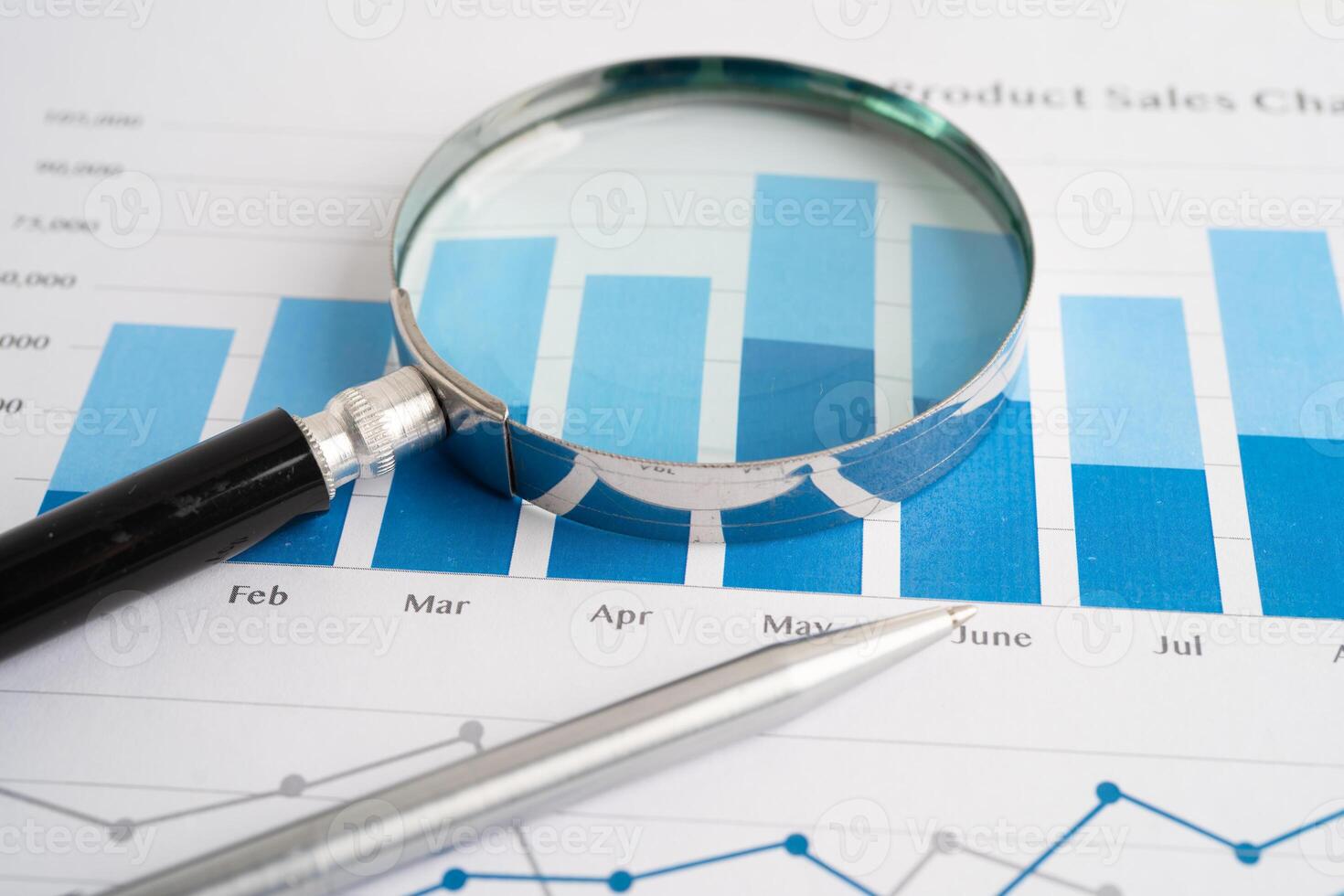 Magnifying glass on charts graphs paper. Financial development photo