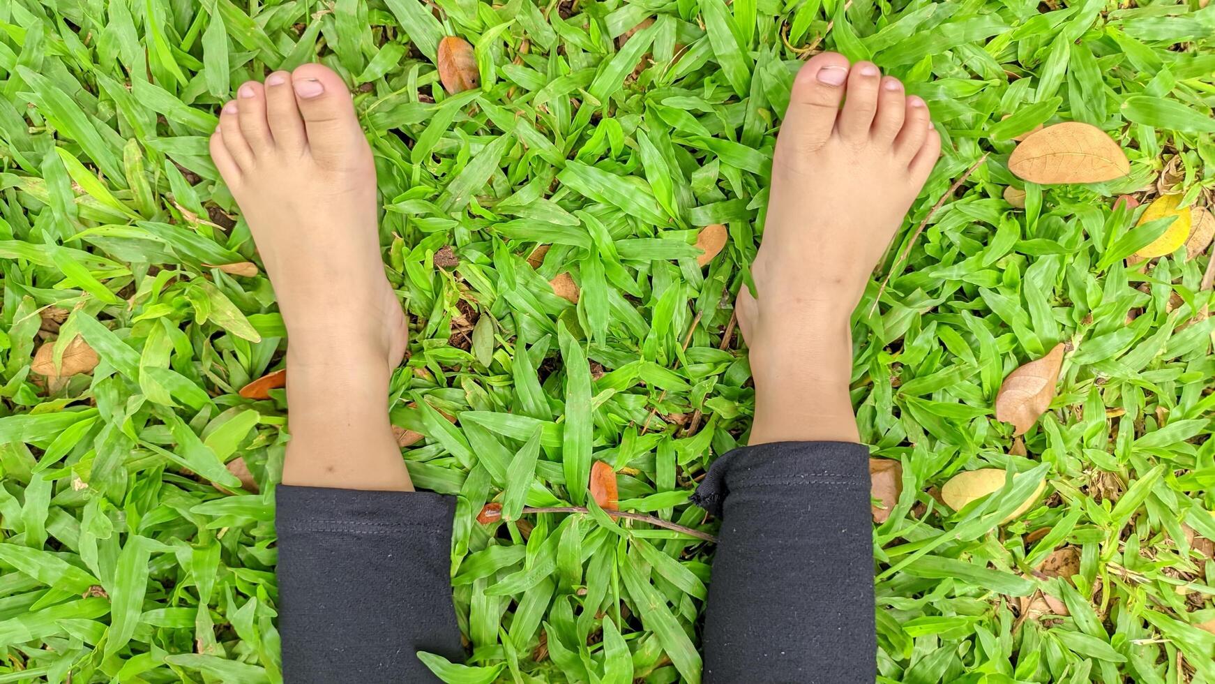 Close Up of Barefoot Child Sitting on Grass, Enjoying a Peaceful Moment photo