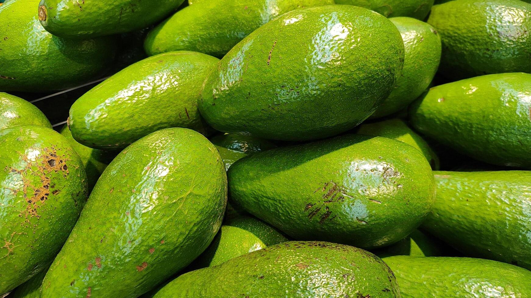 Fresh Avocados Displayed in Grocery Store with Vibrant Green Skin and Texture photo